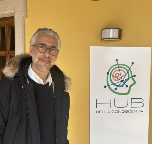 L'immagine raffigura il docente Adduci a fianco del logo dell'Hub della Conoscenza, in Villa Seccamani, sede dell'Hub della Conoscenza 